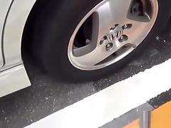 Asian whore pees behind car